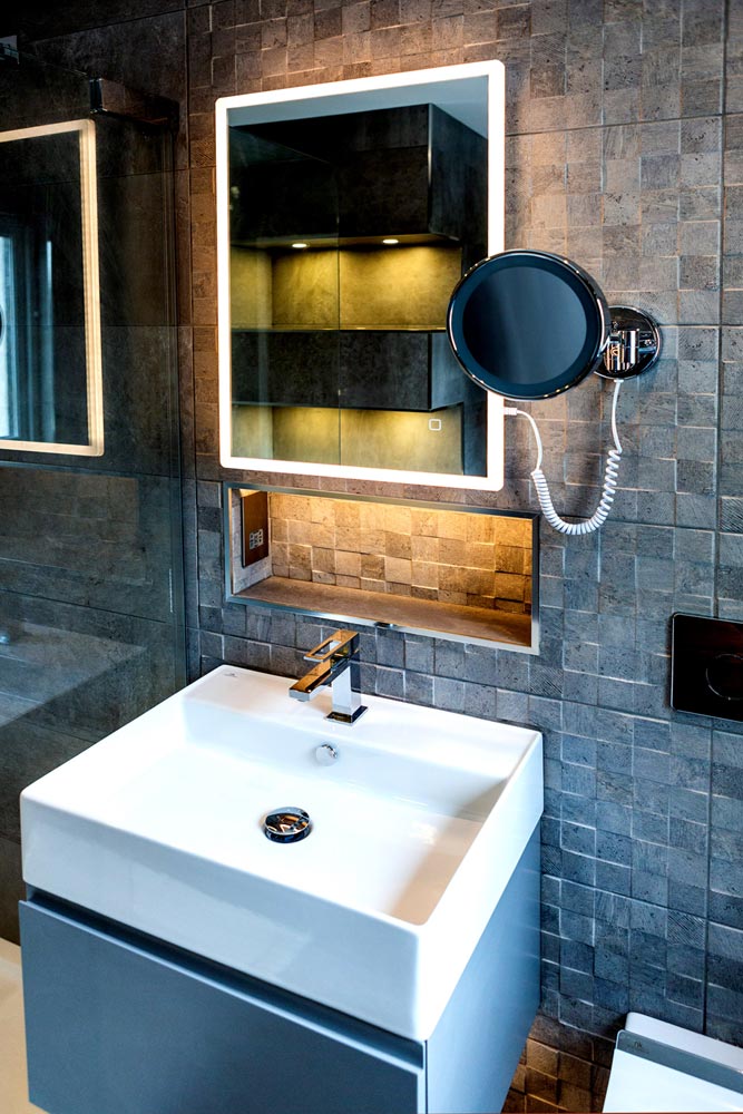 En-suite bathroom installation with Porcelanosa tiles and LED lit mirror.